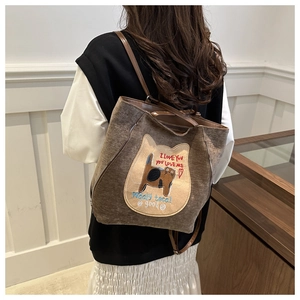 Detail of a brown tote bag featuring cat embroidery and I Love You text texture