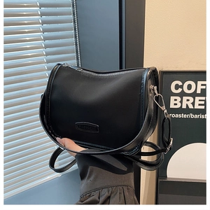 Detail of black matte nylon crescent bag with fashion label and metal zipper closure
