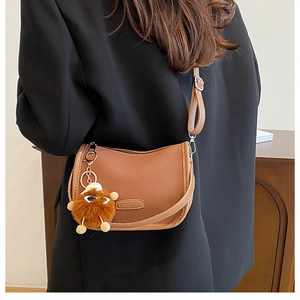 Brown leather crossbody bag with FASHION label and cute plush charm pendant