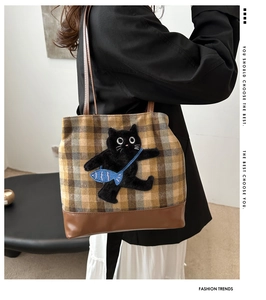 Détail du sac cabas en laine à carreaux avec patch chat 3D en peluche et fond en cuir