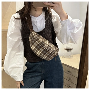 Detail of plaid chest bag with metal triangle logo and brown adjustable strap