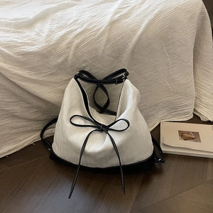 Minimalist black and white bucket tote bag with herringbone pattern and leather trim