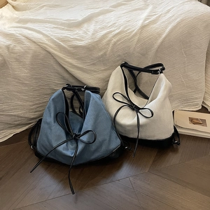 Minimalist leather and canvas patchwork tote bag with stylish bow detail and top handle