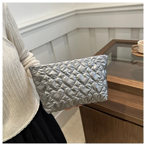 Détail de la pochette argentée métallisée avec motifs cœurs matelassés et zip