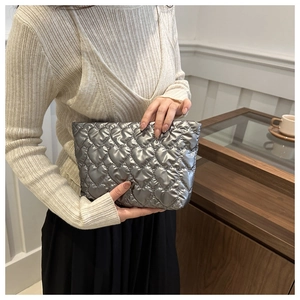 Détail d'un sac à main argenté métallisé avec matelassage en cœur et design minimaliste