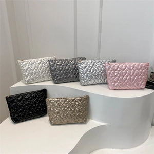 Chic heart-quilted clutch bags in six metallic colors displayed on tiered white stands