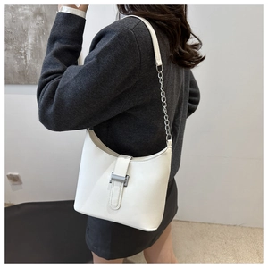 Detail of white leather shoulder bag featuring silver chain strap and metal buckle closure