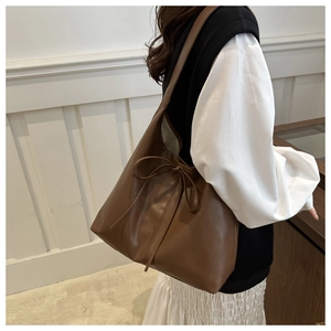 Brown large capacity tote bag shown on a shoulder with vintage minimalist style