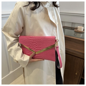 Detail of fuchsia crocodile pattern envelope clutch with gold V-trim and wristlet