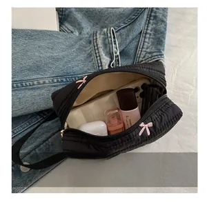 Detailed view of the black quilted makeup bag showing spacious interior and embroidery