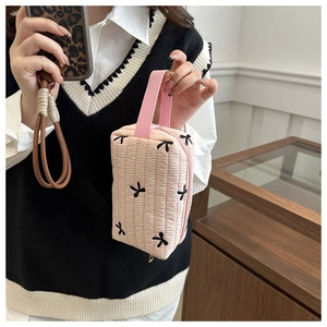 Detail of pink quilted pencil case with black bow patterns and a sturdy handle strap
