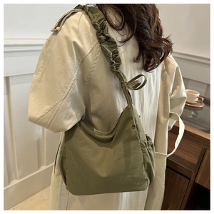 Detail of olive green canvas tote bag with ruched drawstring straps and bow design