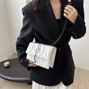 White quilted crossbody bag with silver chain strap and metal logo on model