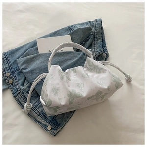 Detail of drawstring handbag featuring green butterfly print and pleated cloud design