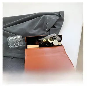 Interior view showing capacity of the brown leather shoulder bag for phone and lipstick