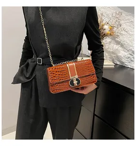 Detail of vintage brown crocodile texture shoulder bag with gold chain and metal lock
