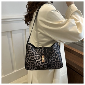 Detail of leopard print handbag featuring a gold rectangular twist lock and smooth texture
