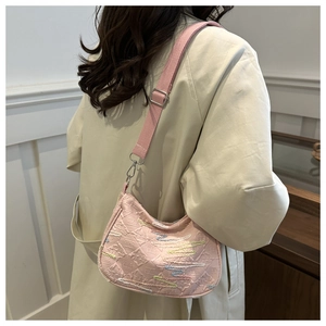Détail du sac bandoulière rose avec broderie et bandoulière ajustable porté par le modèle