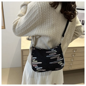 Détail du sac bandoulière noir avec broderie vagues colorées et crochets métalliques
