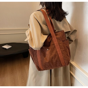 Brown corduroy tote bag detail with wide shoulder strap and side pocket for daily commute