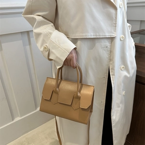 Minimalist tan leather square handbag for women shown from a stylish side angle view