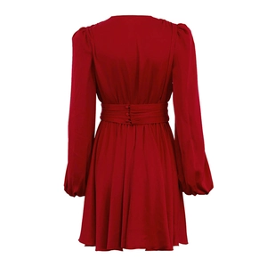 Détail du dos d'une robe en satin rouge avec plis et ceinture large à trois boutons