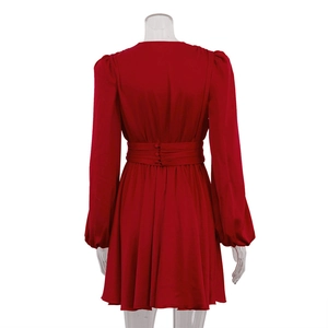Vue détaillée du dos d'une robe mini en satin rouge avec boutons à la taille et manches bouffantes