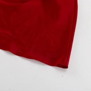 Détail du tissu satiné rouge avec ourlet de précision et texture de soie lisse