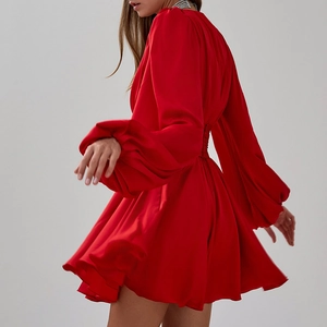 Détail de la robe mini en satin rouge avec manches bouffantes et ourlet fluide