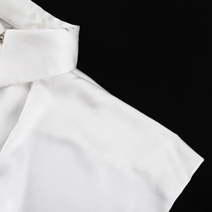 Dettaglio del colletto della camicia in raso bianco e cucitura liscia della spalla