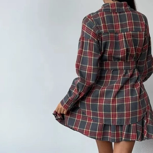 Vue arrière de robe chemise à carreaux manches longues avec ceinture et ourlet volanté