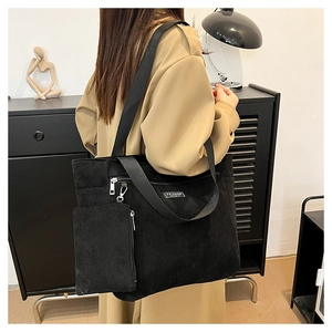 Dettaglio della borsa tote in velluto a coste nero con toppa FASHION e zip argentata