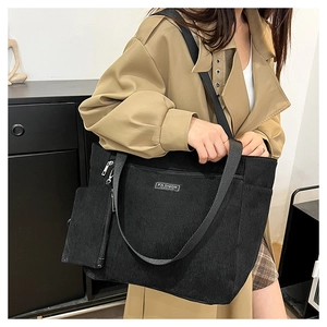 Dettaglio della borsa tote in velluto nero con etichetta Fashion e pochette con cerniera