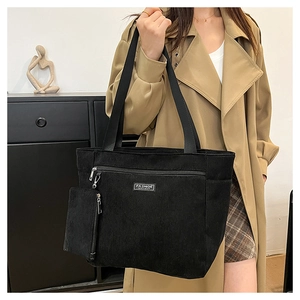 Dettaglio della borsa tote in velluto nero con pochette a zip e etichetta fashion