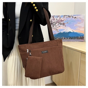 Dettaglio di una borsa tote in velluto marrone con tasca zip e mini pochette