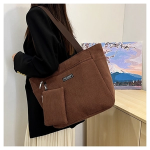 Dettaglio borsa tote in velluto a coste marrone con pochette e tasca con cerniera