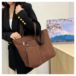 Vista dettagliata della borsa tote in velluto marrone con tasca a zip e dettagli dorati