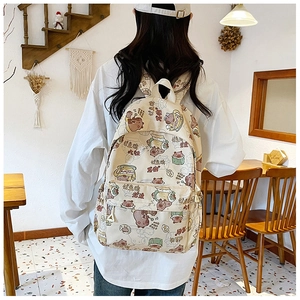 Detail eines beigen Canvas-Rucksacks mit süßen Capybara-Prints und Schriftzügen