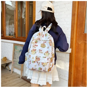 Outdoor-Lifestyle-Foto eines weißen Canvas-Rucksacks mit niedlichen Capybara-Motiven