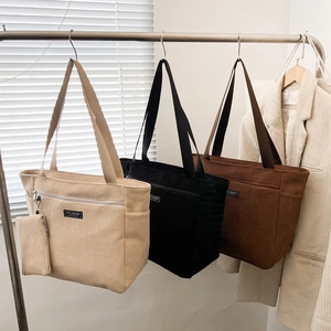 Grande borsa tote in velluto a coste color kaki e nero con etichetta moda per pendolari