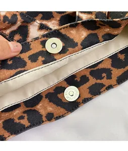 Detail of durable silver magnetic buckle closure on a leopard print canvas tote bag