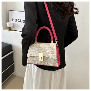 Détail du sac à main tissé beige avec broderie florale et bandoulière en cuir rose