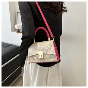 Détail du sac tissé avec broderie florale et poignée tressée en cuir rose élégant