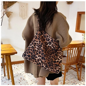 Fashionable leopard print canvas tote bag shown from behind on model in a cozy cafe