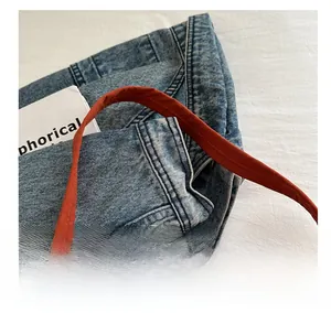 Detail shot of orange-brown canvas shoulder strap with precision stitching and durable texture