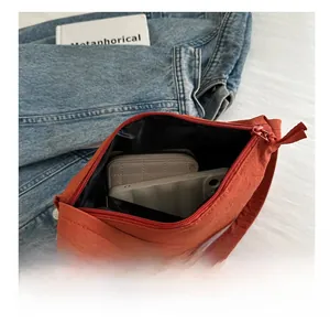 Interior view of the orange canvas bucket bag showing capacity for phone and wallet