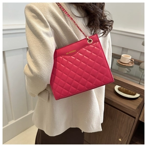 Detail of rose pink quilted chain bag with gold metal logo and braided leather strap