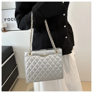 Close-up of silver quilted faux leather texture and metallic chain strap detail