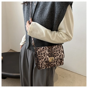 Close-up of leopard print crossbody bag with gold metal clasp and adjustable strap