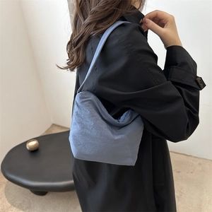 Sac seau bleu brume minimaliste avec texture délicate porté par un mannequin
